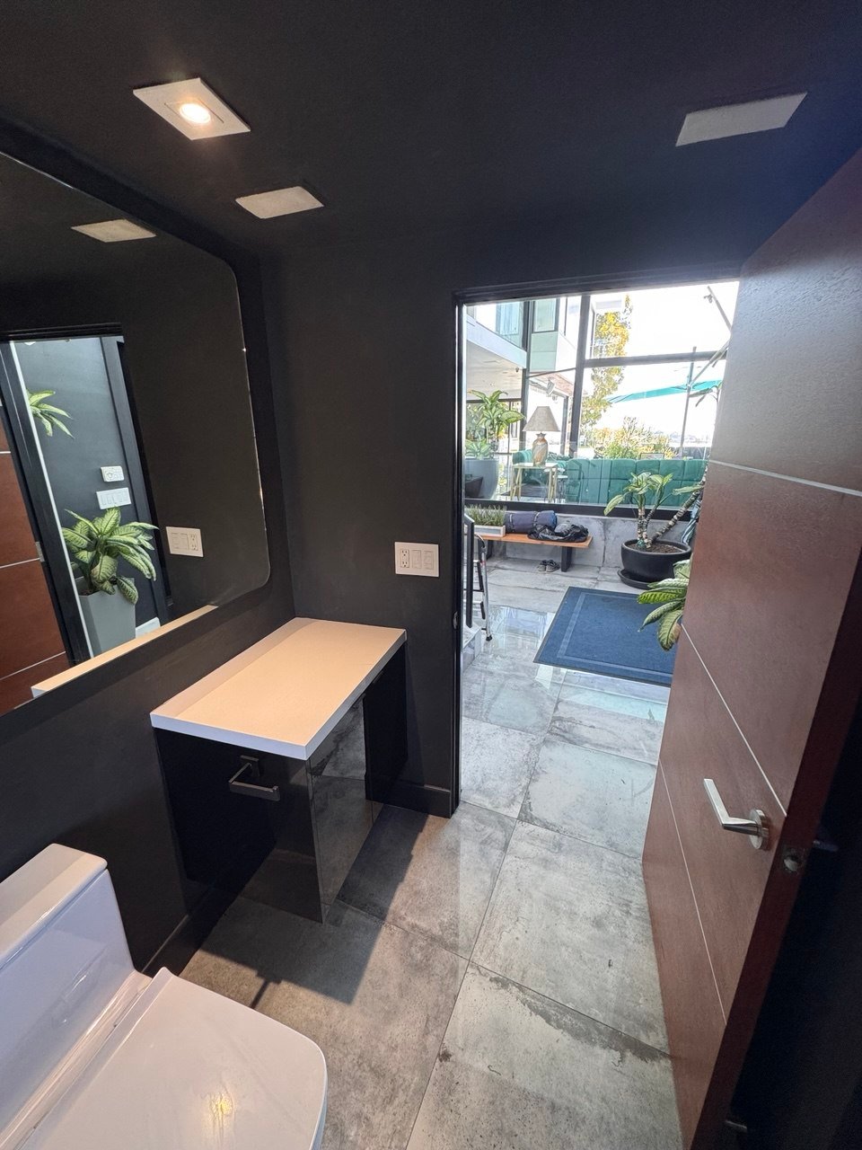 Black clay powder room opening to terrace, Los Angeles